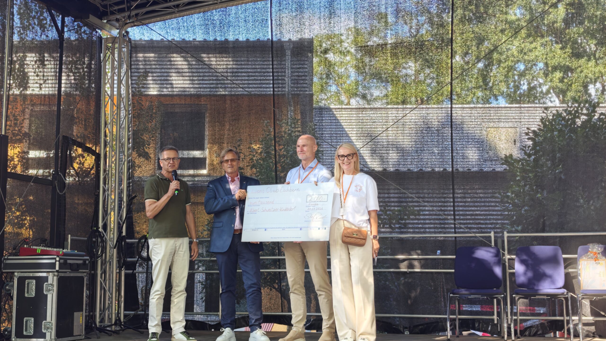 Stefan Raab und Ulf-Peter Noetzel vom Lions Club Eschborn übergaben auf dem Sommerfest eine Spende über 2.000 Euro an Susanne Högler und Dominik Melzig auf der Bühne