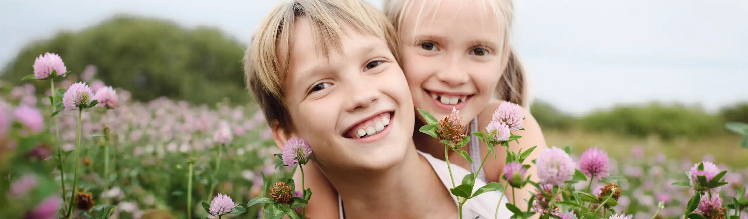 Zwei lachende Kinder auf einer blühenden Wiese